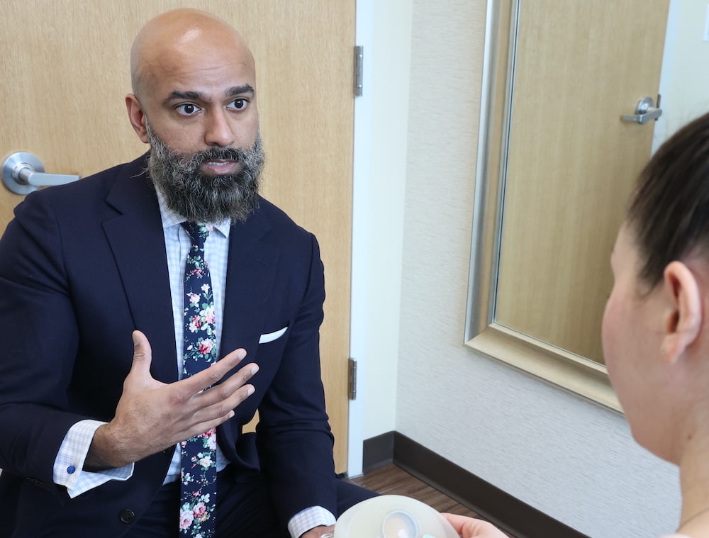 Dr. George showing a patient a breast implant